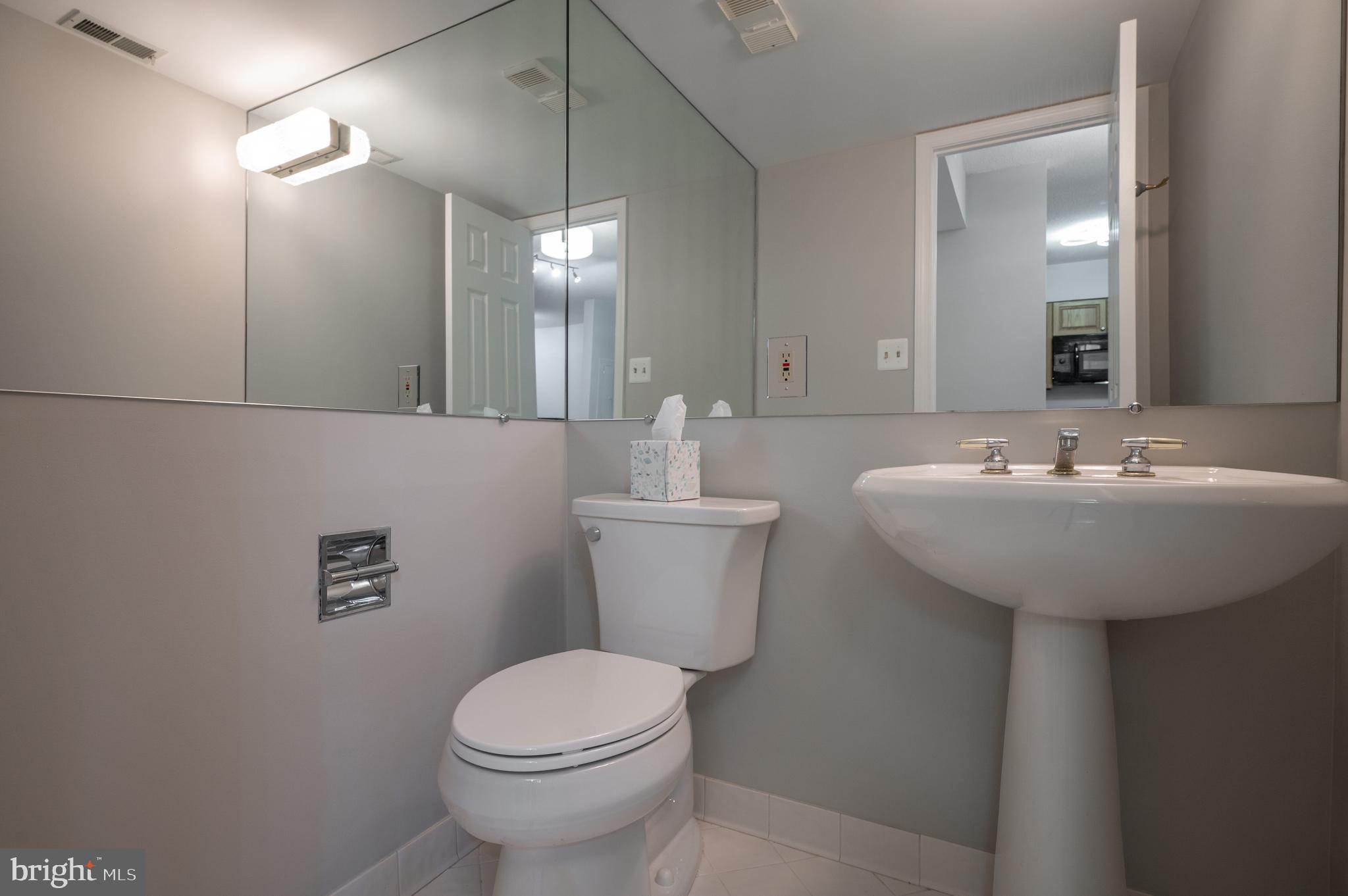 5000 Battery Lane, Unit 207 Bethesda, MD 20814 - Photo 25 of 34 a bathroom with a sink a toilet and mirror