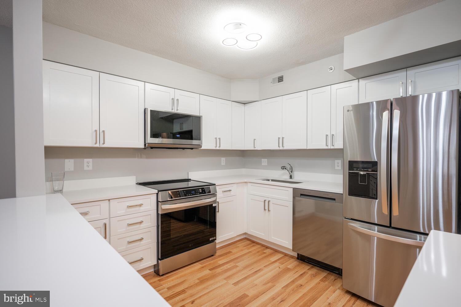 5000 Battery Lane, Unit 207 Bethesda, MD 20814 - Photo 7 of 34 a kitchen with granite countertop a refrigerator stove and microwave
