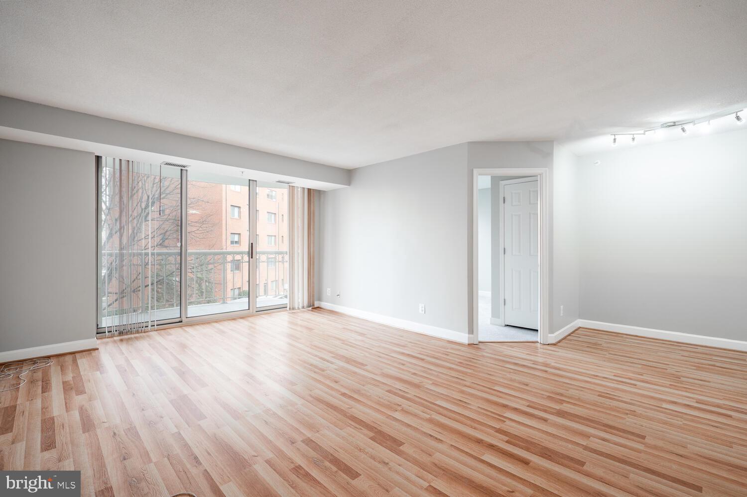5000 Battery Lane, Unit 207 Bethesda, MD 20814 - Photo 10 of 34 a view of an empty room with wooden floor and a window