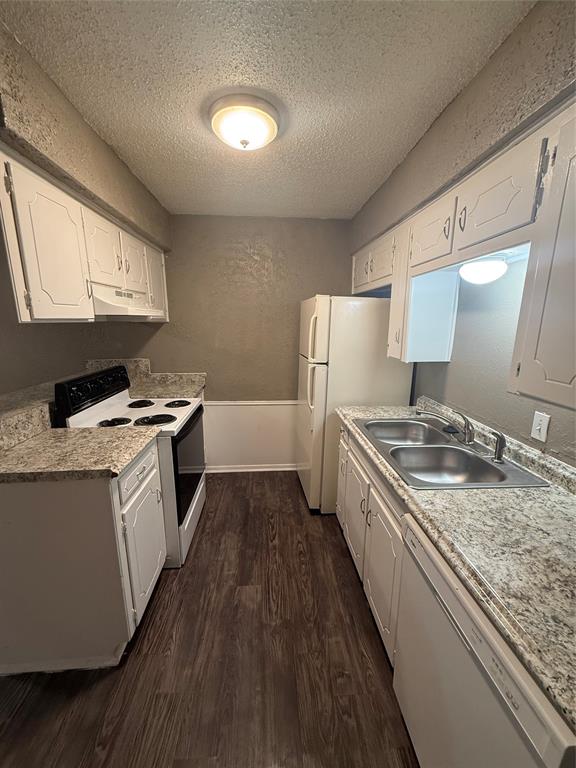 708 East Pecan Street, Unit 712 Hurst, TX 76053 - Photo 6 of 15 Galley kitchen featuring white cabinetry, wood-finish flooring, a double basin stainless steel sink, a range with a griddle, and a white refrigerator