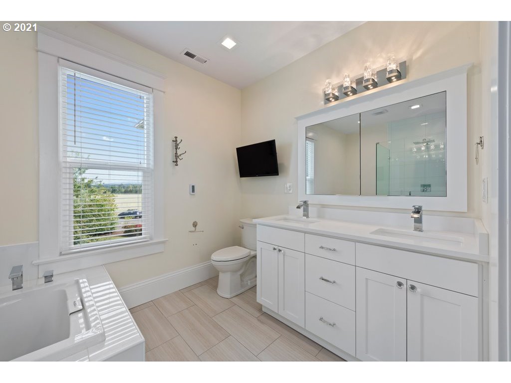 36902 South Kropf Road Woodburn, OR 97071 - Photo 16 of 26 a bathroom with a toilet a sink a mirror and a window