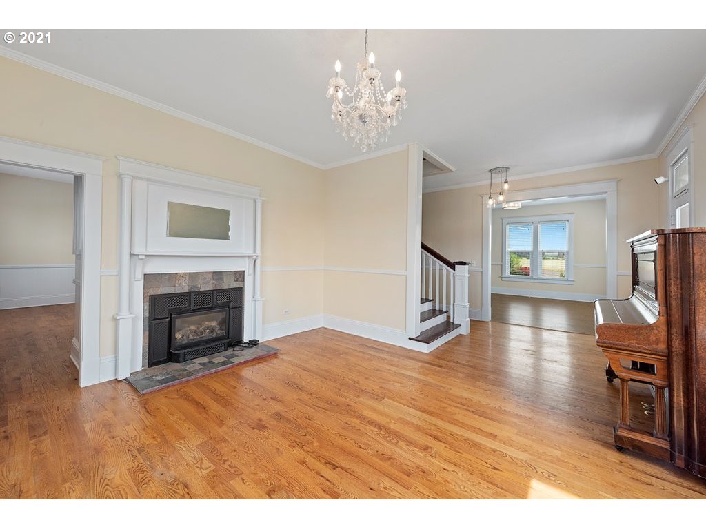 36902 South Kropf Road Woodburn, OR 97071 - Photo 3 of 26 a view of a livingroom with a fireplace a chandelier and wooden floor