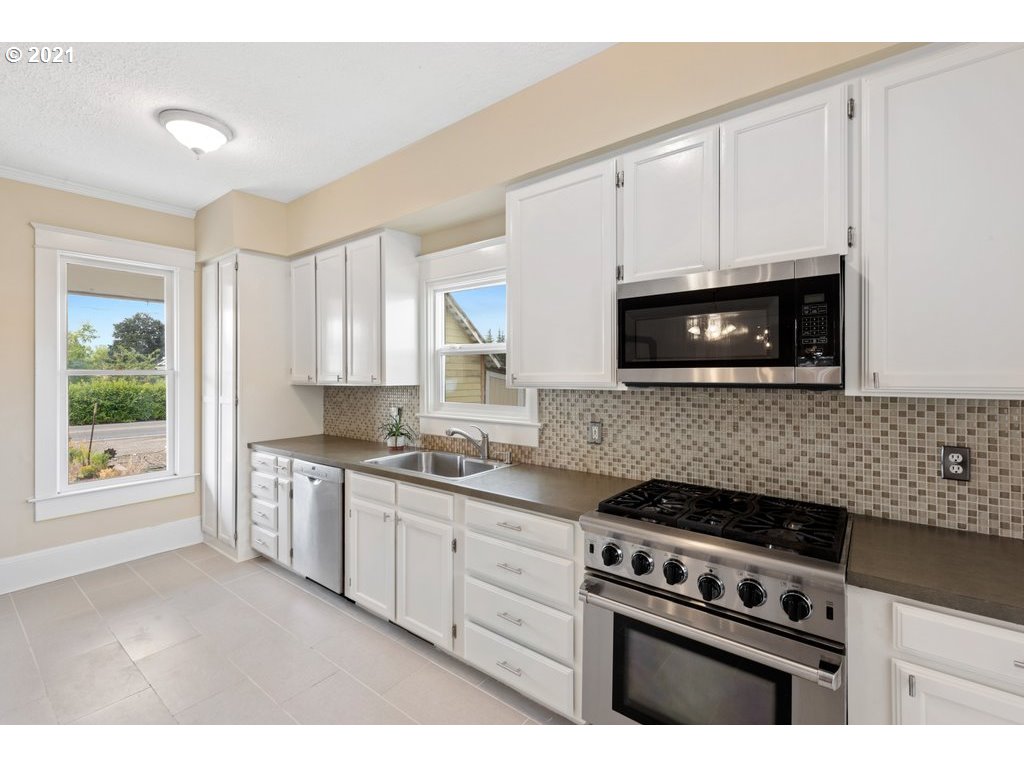 36902 South Kropf Road Woodburn, OR 97071 - Photo 6 of 26 a kitchen with stainless steel appliances white cabinets granite counter tops and a window