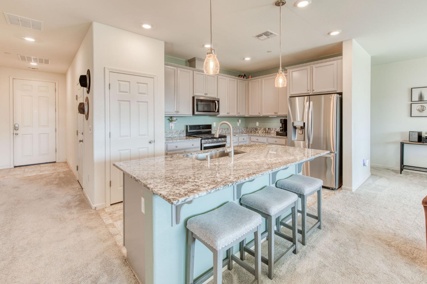 3606 Morro Rock Place Madera, CA 93637 - Photo 13 of 46 a kitchen with kitchen island granite countertop a counter space dining table stainless steel appliances and a counter top space