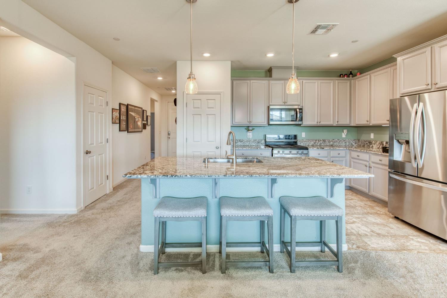 3606 Morro Rock Place Madera, CA 93637 - Photo 14 of 46 a kitchen with kitchen island cabinets and refrigerator