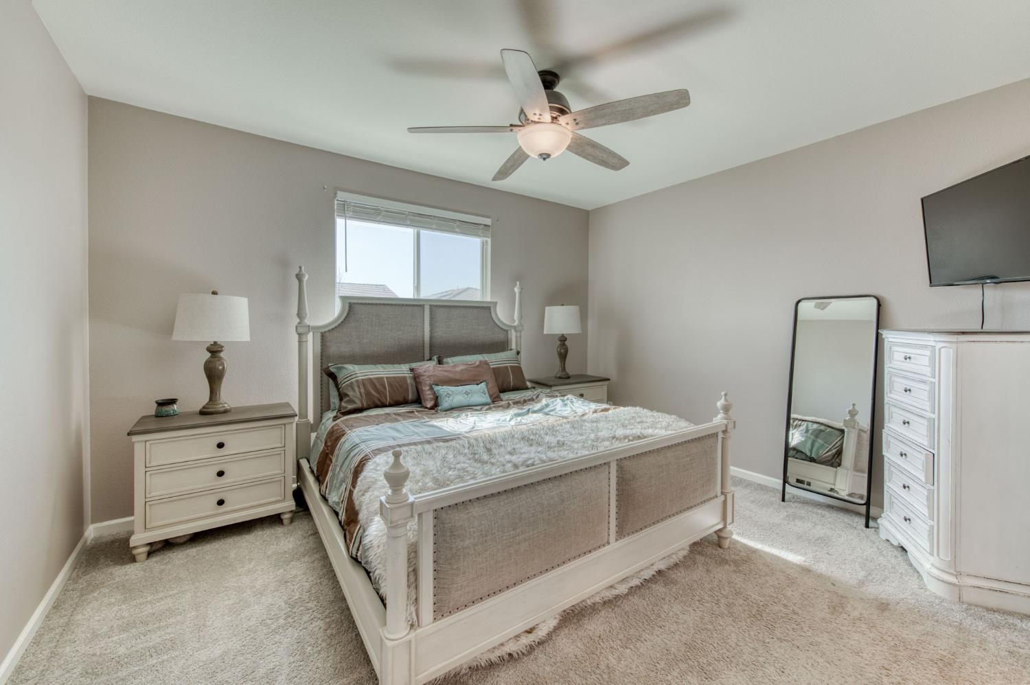 3606 Morro Rock Place Madera, CA 93637 - Photo 26 of 46 a bedroom with a bed and a chandelier