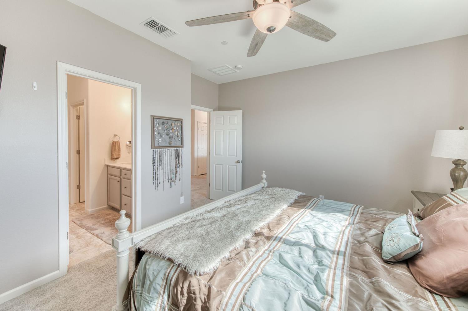 3606 Morro Rock Place Madera, CA 93637 - Photo 28 of 46 a bedroom with a bed and a chandelier