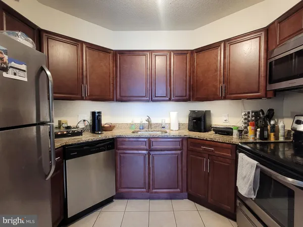 a kitchen with stainless steel appliances granite countertop wooden cabinets a stove a sink and dishwasher