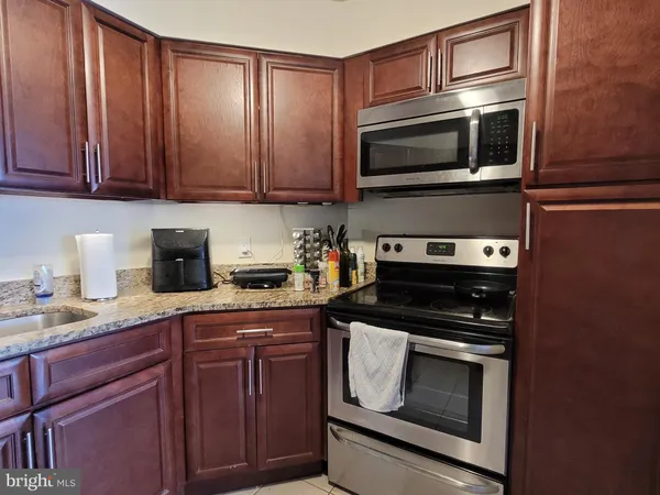 a kitchen with granite countertop cabinets stainless steel appliances and wooden cabinets