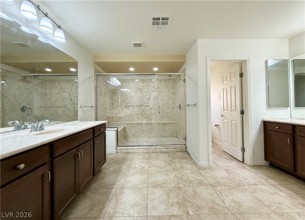 6459 Parrot Ridge Court Las Vegas, NV 89139 - Photo 15 of 23 Primary bath Dual vanities and a spacious walk-in shower elevate this well-appointed bathroom.