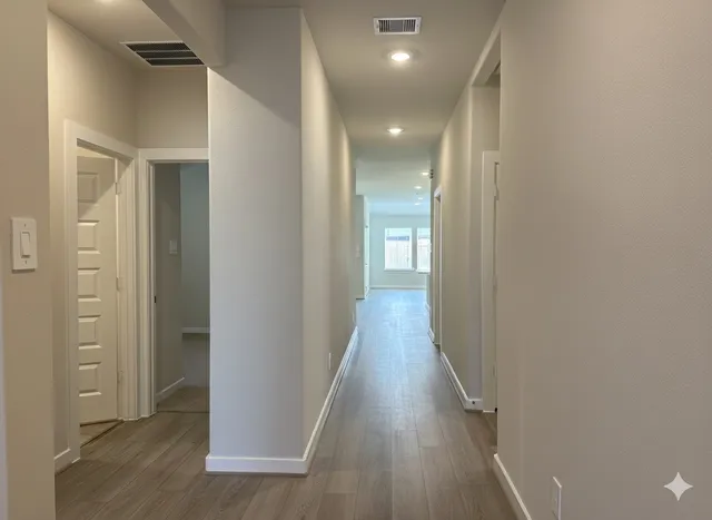 a view of a hallway with wooden floor
