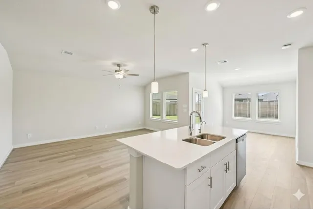 a kitchen with a sink cabinets and wooden floor