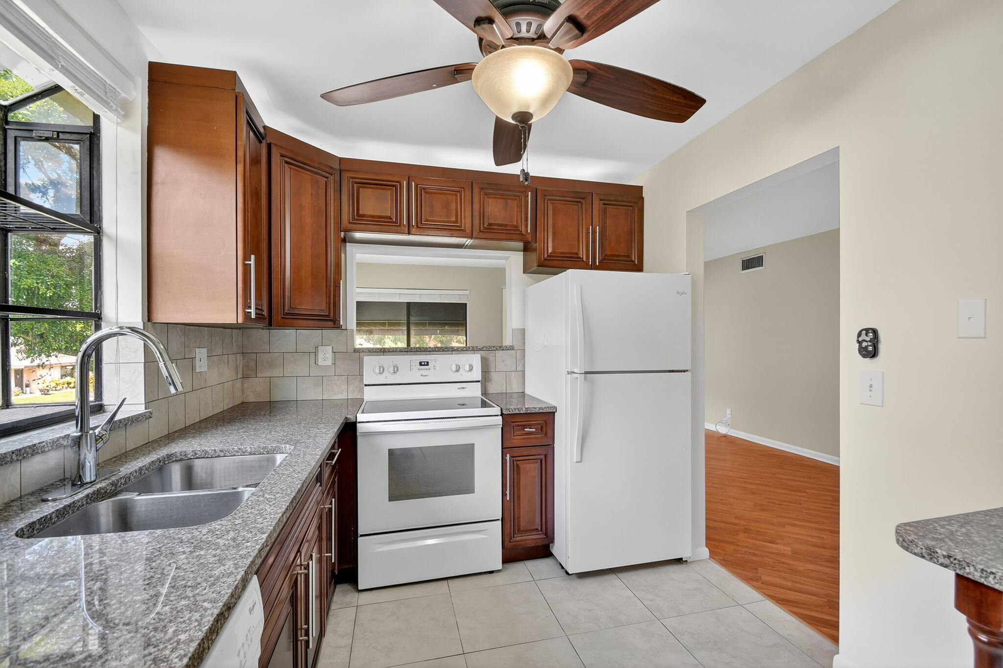 5040 Rose Hill Drive, Unit 206 Boynton Beach, FL 33437 - Photo 14 of 54 a kitchen with granite countertop a sink stainless steel appliances and cabinets