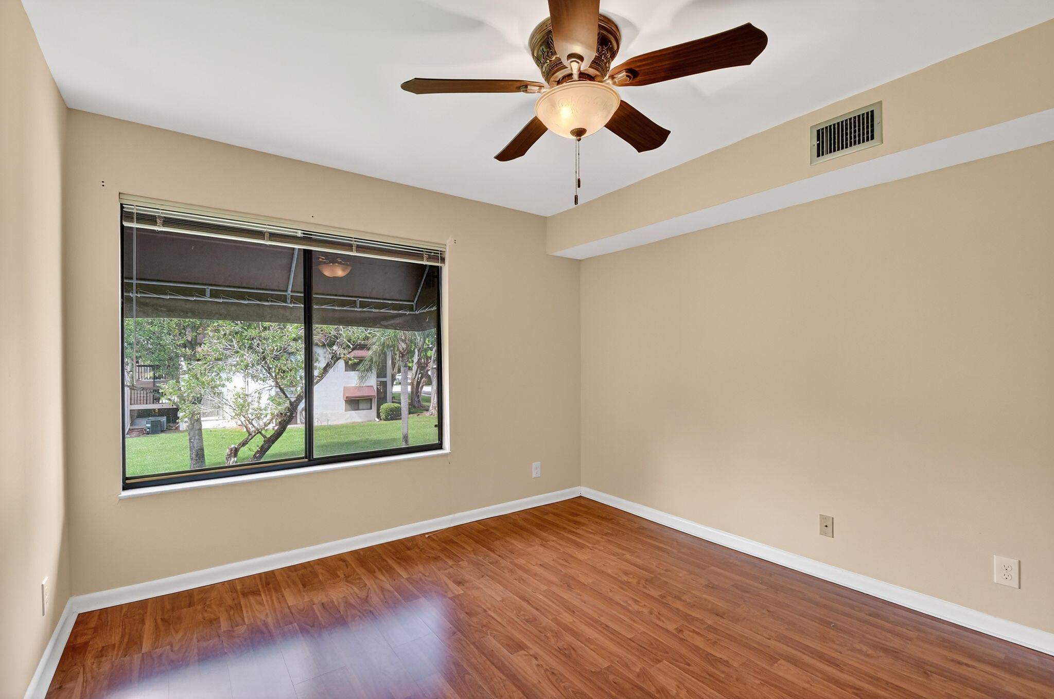 5040 Rose Hill Drive, Unit 206 Boynton Beach, FL 33437 - Photo 31 of 54 a view of an empty room with wooden floor and a window