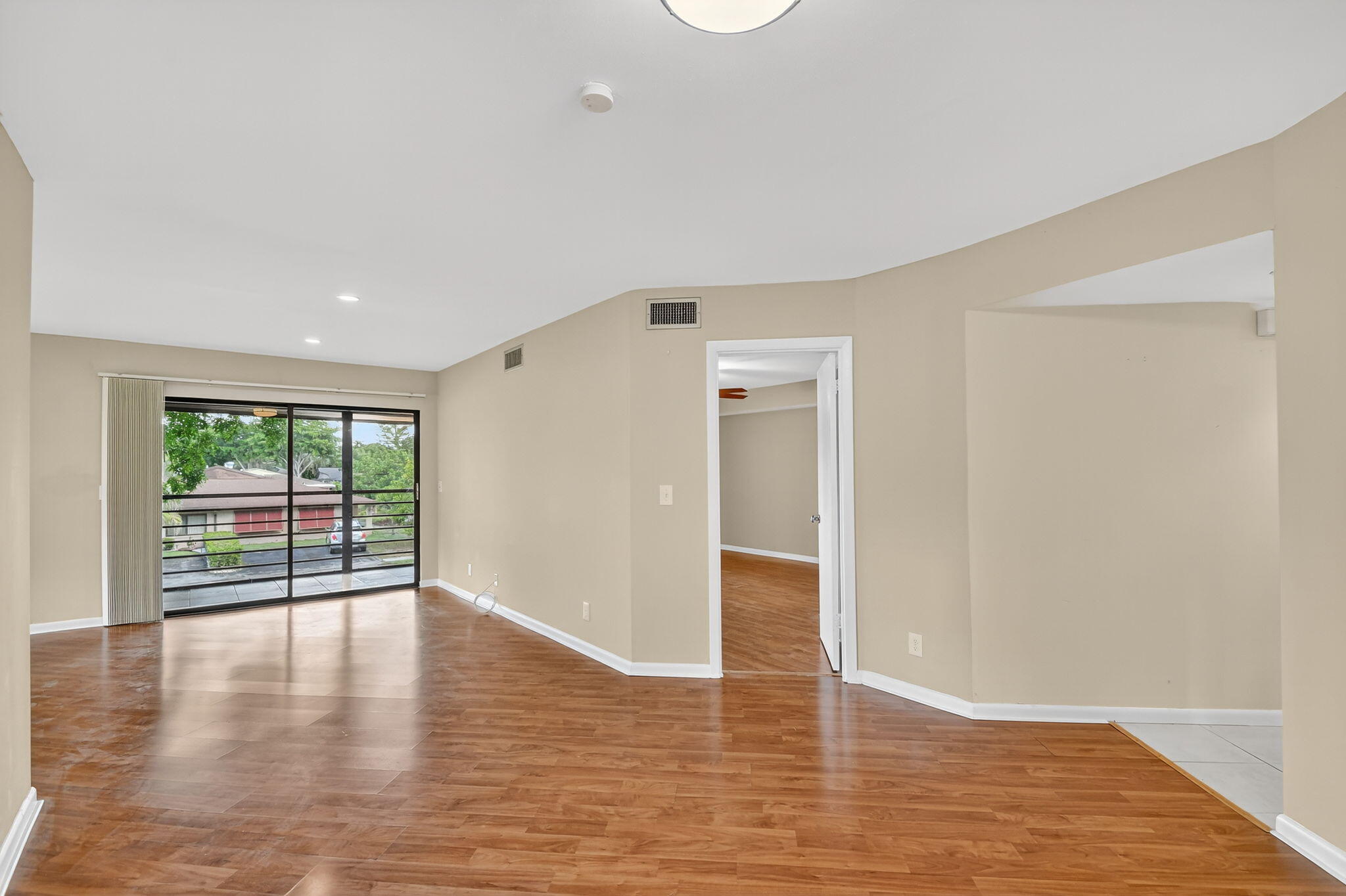 5040 Rose Hill Drive, Unit 206 Boynton Beach, FL 33437 - Photo 10 of 54 a view of an empty room with wooden floor and a window