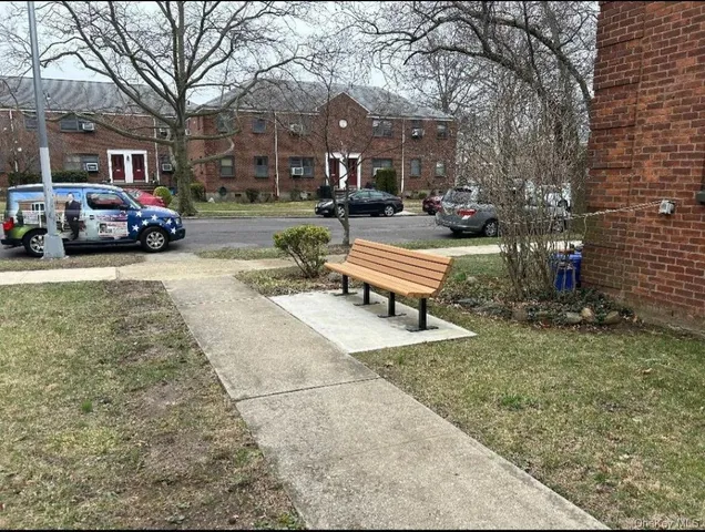 a building outdoor space with lots of cars parked on the roadside