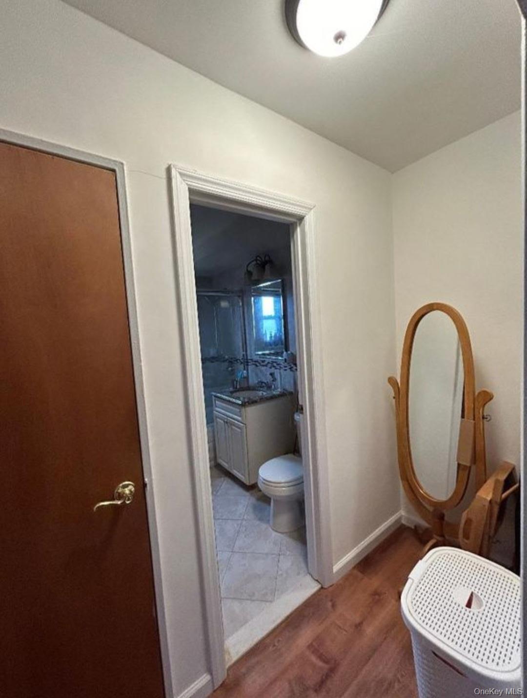 199-05 21st Avenue, Unit 1 Queens, NY 11357 - Photo 13 of 13 a bathroom with a toilet a sink and a mirror