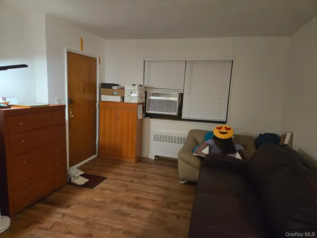 a living room with stainless steel appliances furniture a refrigerator and a kitchen island