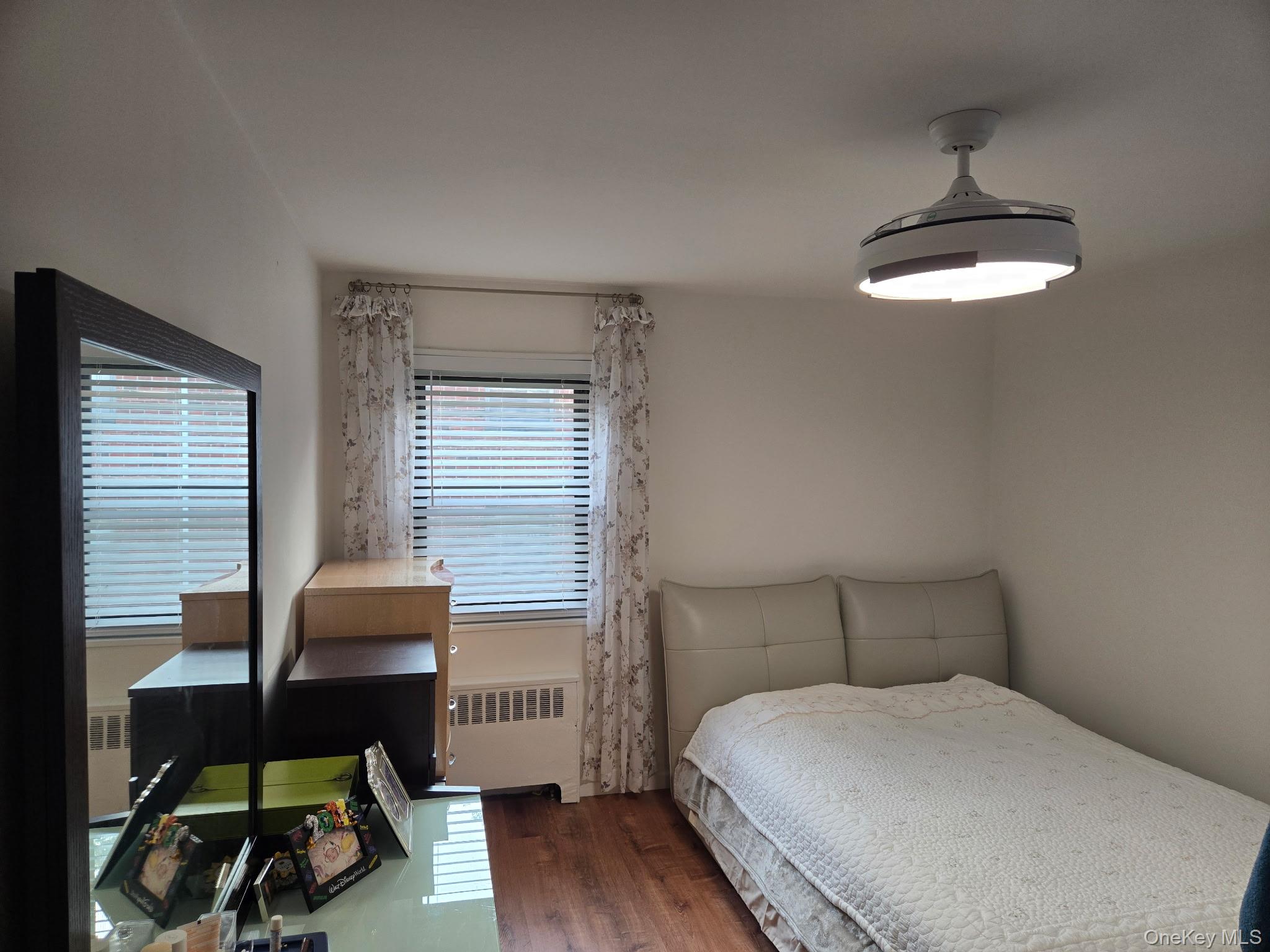 199-05 21st Avenue, Unit 1 Queens, NY 11357 - Photo 8 of 13 a bedroom with a bed and a chair