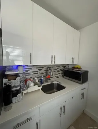a kitchen with a sink a stove and cabinets