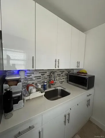 a kitchen with a sink a stove and cabinets