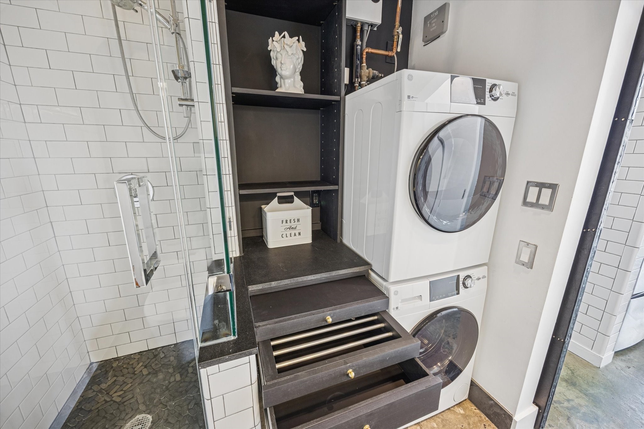 2000 Bagby Street, Unit 5400 Houston, TX 77002 - Photo 14 of 47 First level bath shower and efficient laundry and butler cabinet with pull outs, folding station, drying rack, and storage.