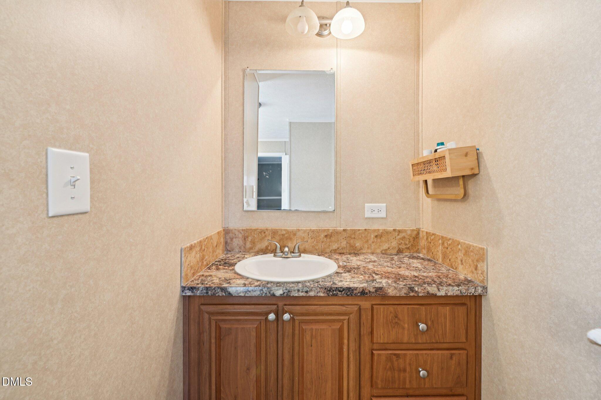 2186 Piney Grove Church Road Kenly, NC 27542 - Photo 15 of 30 a bathroom with a granite countertop sink and a mirror