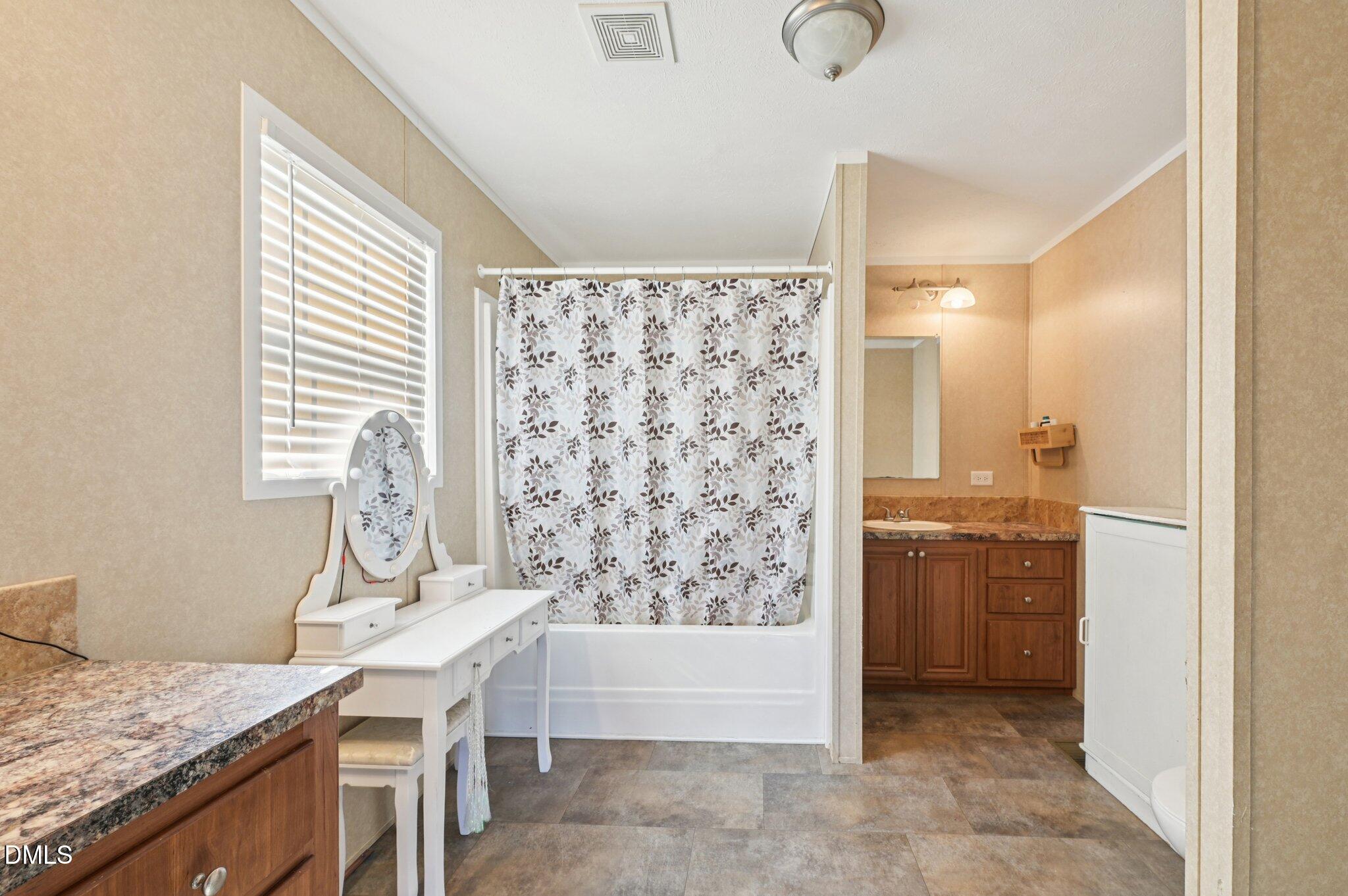 2186 Piney Grove Church Road Kenly, NC 27542 - Photo 16 of 30 a bathroom with a granite countertop sink a mirror and shower