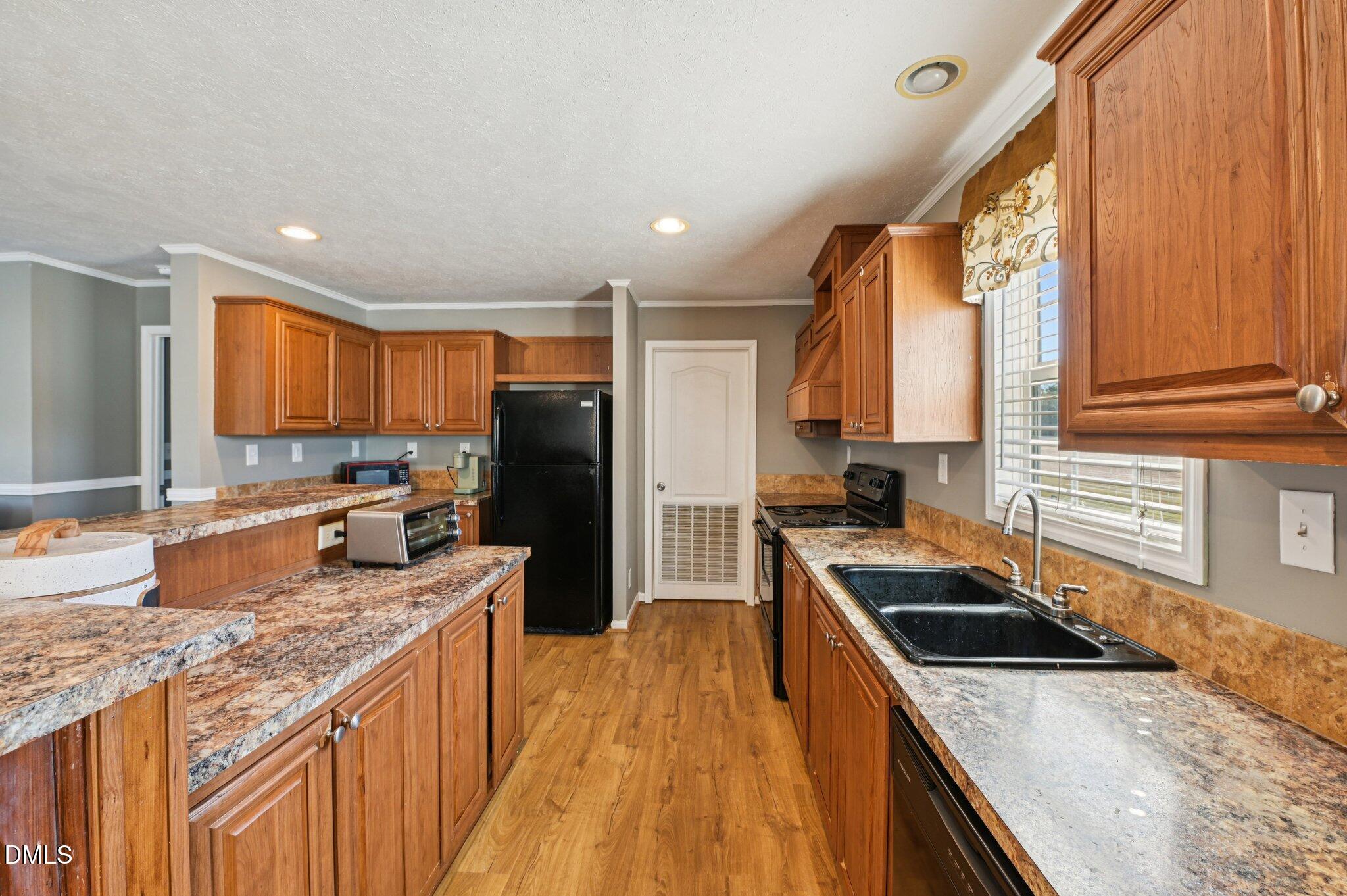 2186 Piney Grove Church Road Kenly, NC 27542 - Photo 9 of 30 a kitchen with stainless steel appliances granite countertop a stove a sink and a refrigerator
