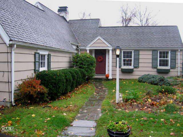 217 Olmstead Hill Road Wilton, CT 06897 - Photo 1 of 1 a front view of a house with a garden