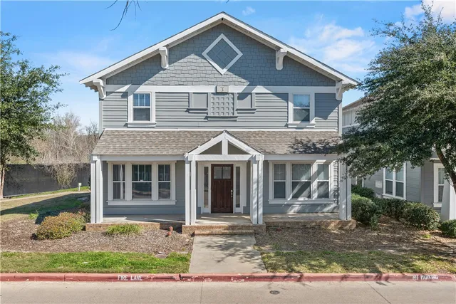 a front view of a house with a yard and potted plants