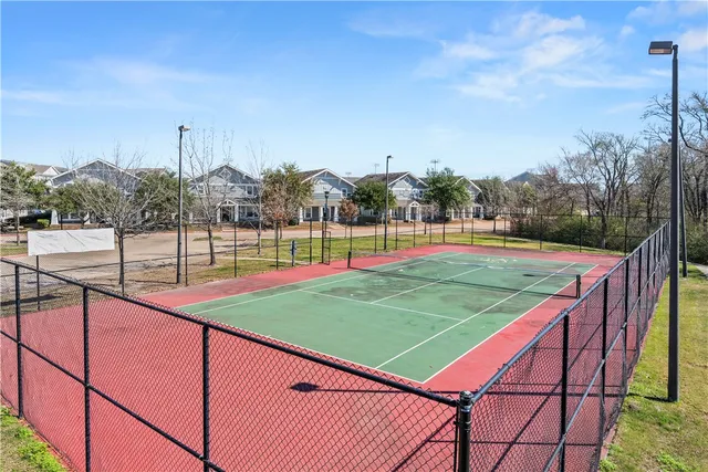 a view of a tennis ground with large trees