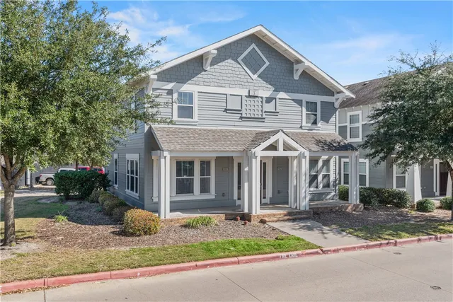 a front view of a house with a garden and garage