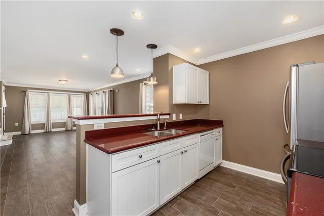 a kitchen with stainless steel appliances granite countertop a sink a stove and a refrigerator