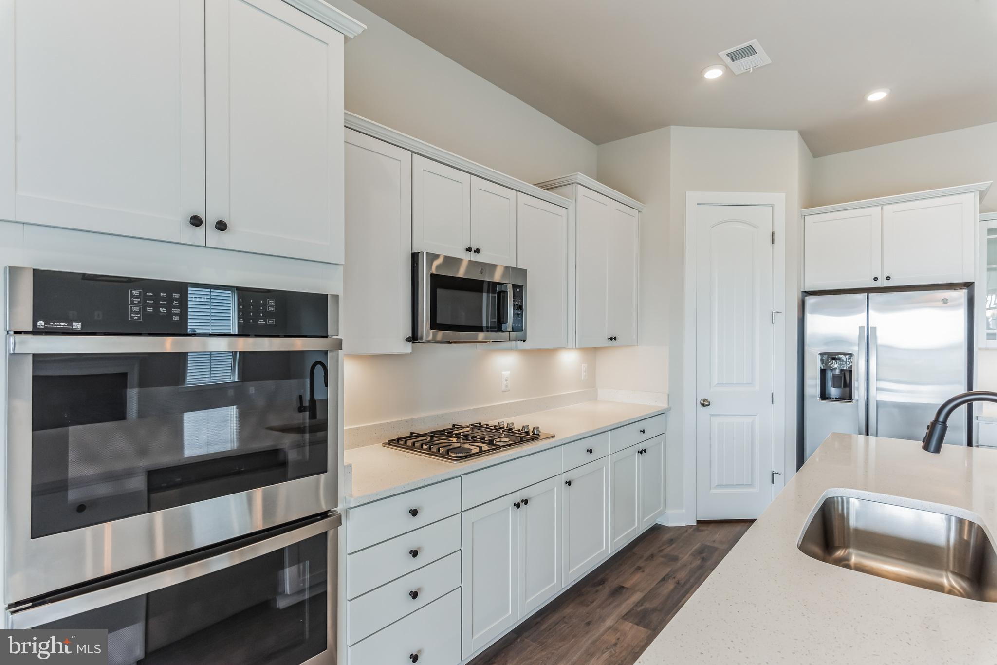 21 Golden Raintree Court Middletown, DE 19709 - Photo 4 of 28 a kitchen with granite countertop white cabinets and stainless steel appliances