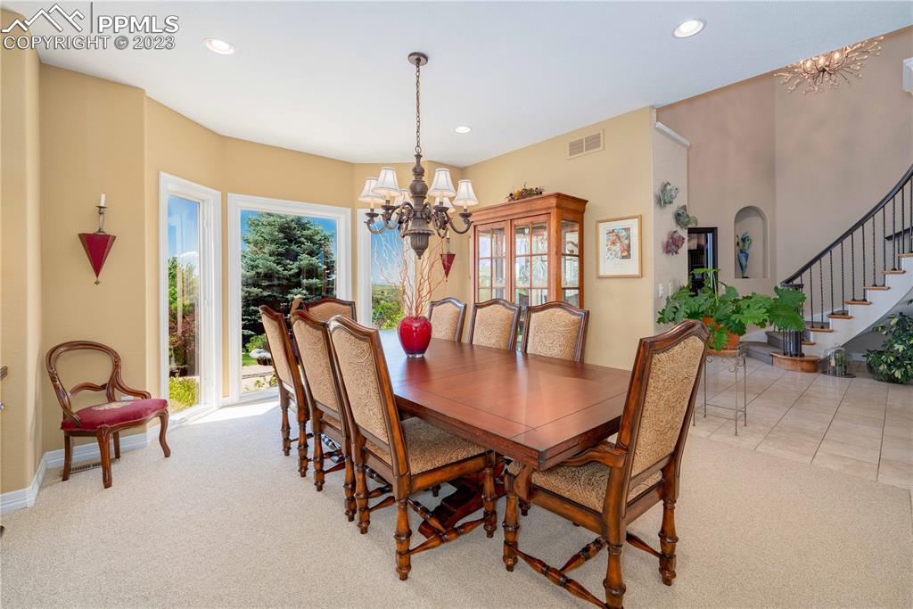 8760 Ridgepointe Drive Castle Pines, CO 80108 - Photo 17 of 50 a view of a dining room with furniture and chandelier