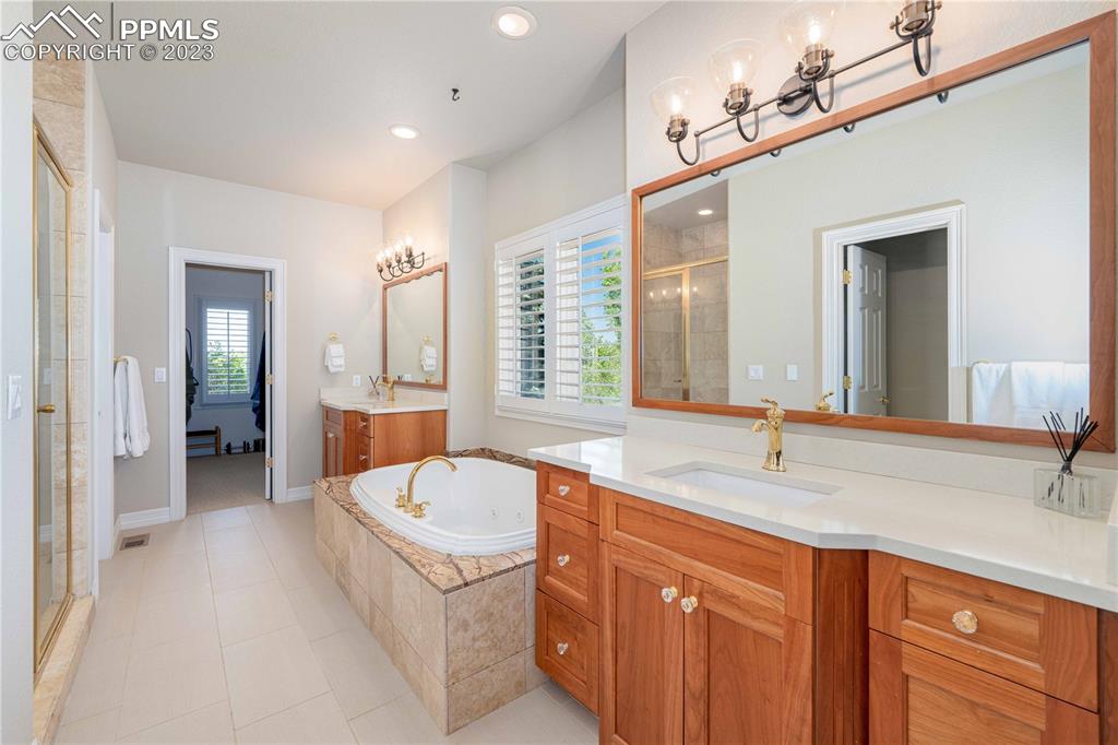 8760 Ridgepointe Drive Castle Pines, CO 80108 - Photo 32 of 50 a bathroom with a sink double vanity granite tub shower and a mirror
