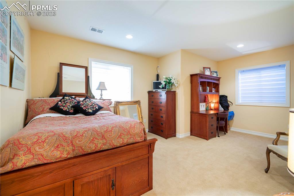 8760 Ridgepointe Drive Castle Pines, CO 80108 - Photo 38 of 50 a bedroom with a bed and wooden floor
