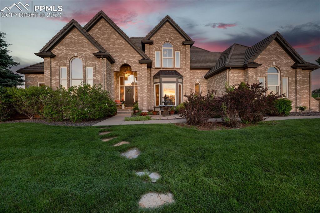 8760 Ridgepointe Drive Castle Pines, CO 80108 - Photo 50 of 50 a front view of a house with a garden and plants