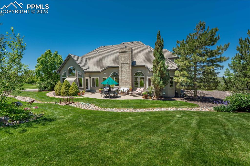 8760 Ridgepointe Drive Castle Pines, CO 80108 - Photo 5 of 50 a front view of a house with garden