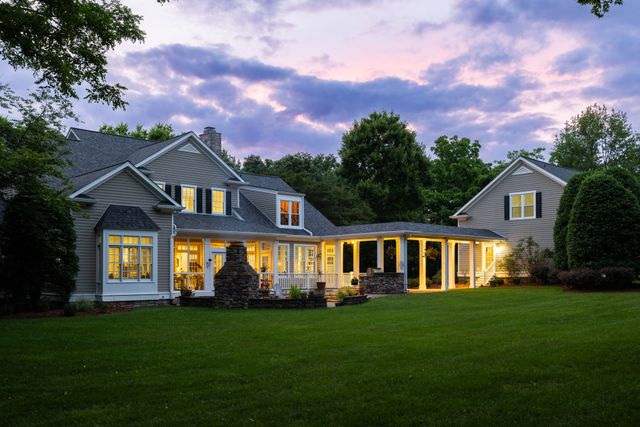 a front view of a house with a yard and trees