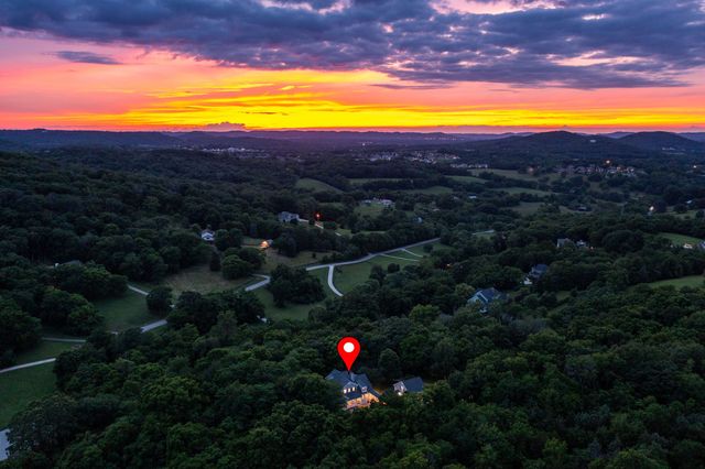 a view of a livingroom with furniture wooden floor windows and a chandelier