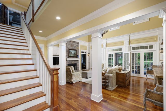 a kitchen with a stove a refrigerator a dining table and chairs with wooden floor