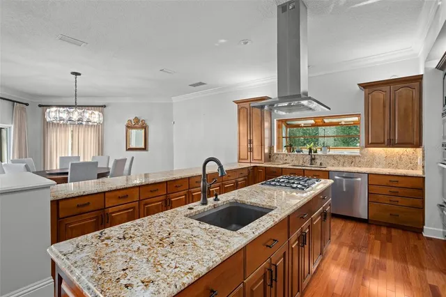 a kitchen with stainless steel appliances granite countertop a sink stove and refrigerator