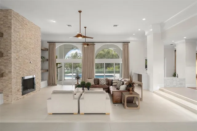 a living room with furniture a fireplace and a chandelier