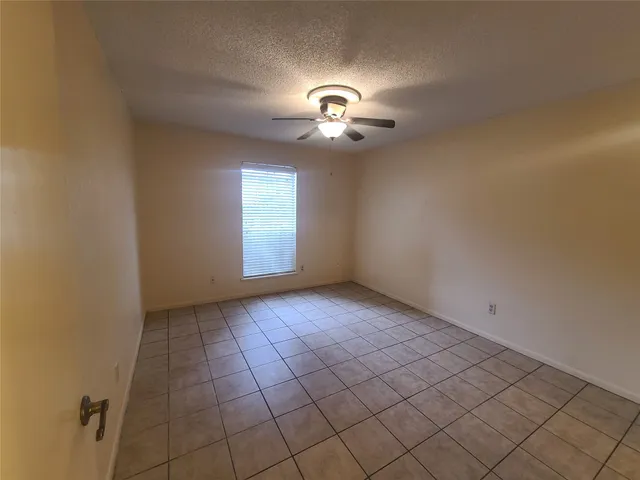 en empty room with windows and fan