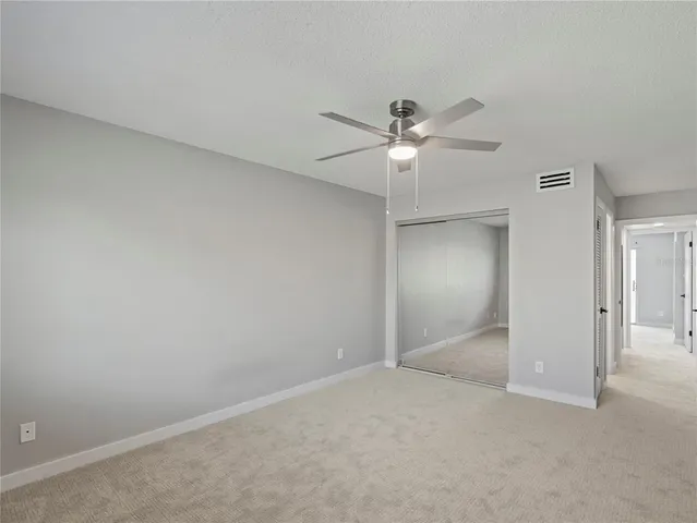 an empty room with a ceiling fan and a fan