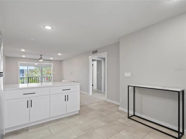 a large white kitchen with a sink a window and stainless steel appliances