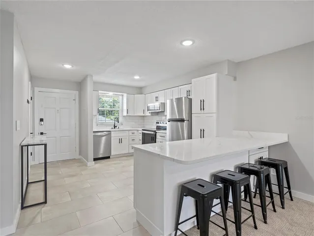 a kitchen with white cabinets and stainless steel appliances