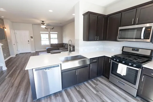 a kitchen with a sink stove and microwave